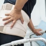 Person wearing BraceAbility orthopedic knee and back support braces for pain relief, injury recovery, and improved daily mobility